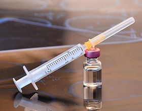 Vial of BOTOX and syringe on reflective surface