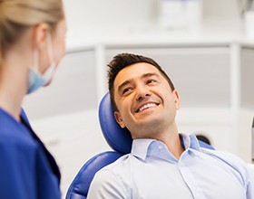 A female dentist with a happy male patient at a clinic