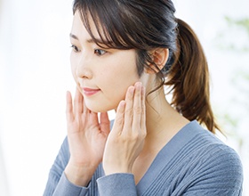 Concerned woman touching the sides of her face