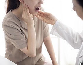 Dental team member assessing patient’s TMD symptoms