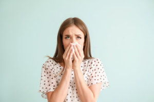 Woman blowing her nose and looking stressed